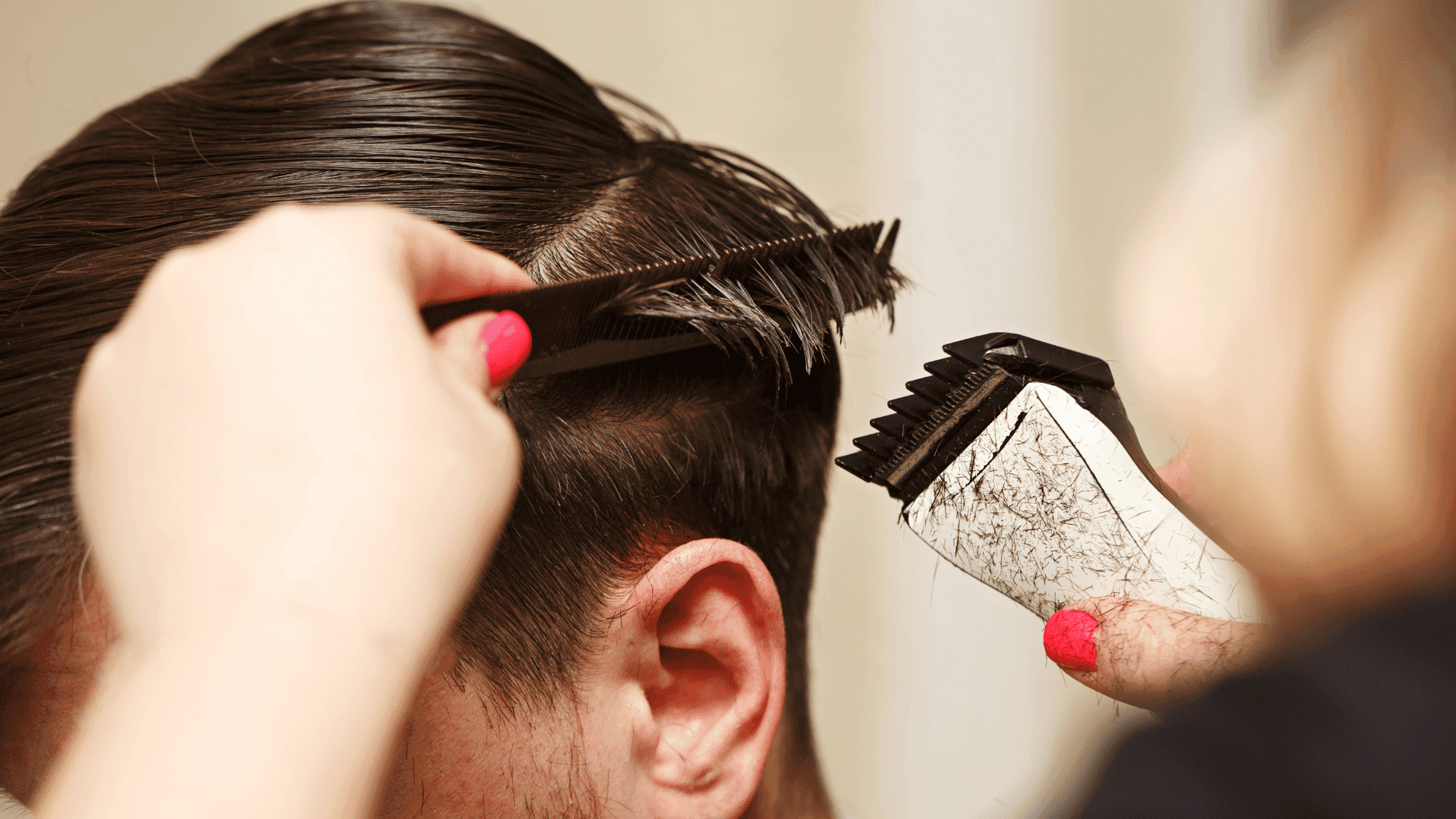 Haircut in progress with scissors and electric clippers trimming a man's hair.